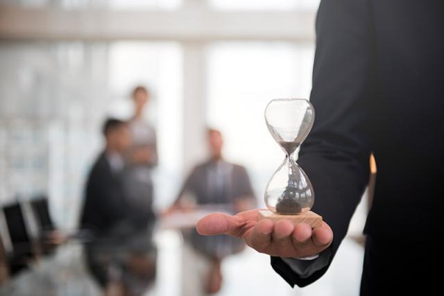 Mann hält Sanduhr