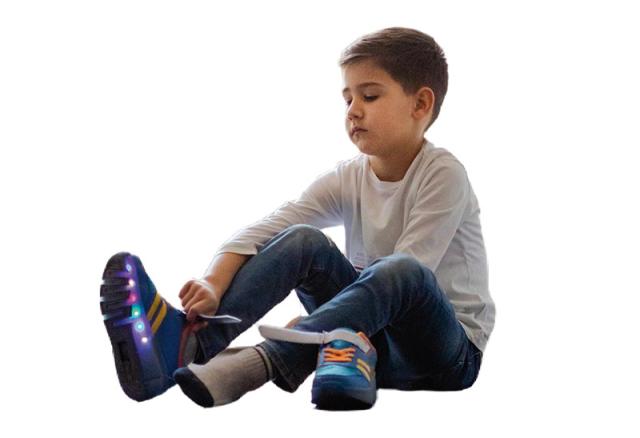 Kind zieht Schuh mit Leuchtdioden an